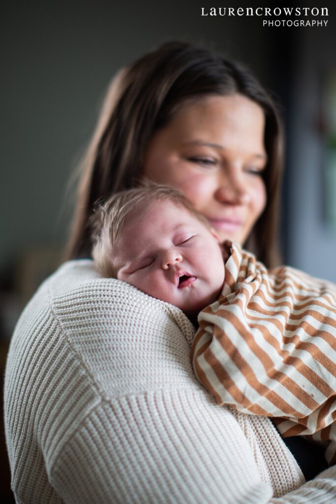 Mom holding newborn for photo session in home